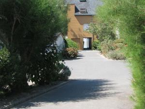 an empty driveway leading to a house with trees at LES BERNACHES in Le Crotoy