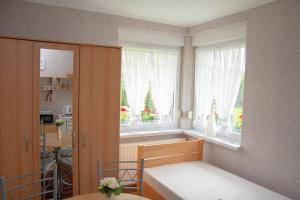 Zimmer mit einem Bett und einem Fenster mit weißen Vorhängen in der Unterkunft Zielona Okiennica Chillout in Chłopy