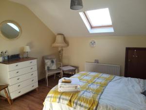 a bedroom with a bed and a dresser and a window at Antrim Heights BnB in Antrim