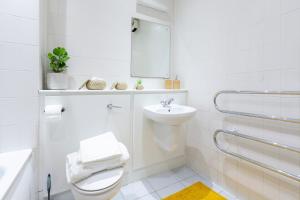 a white bathroom with a toilet and a sink at The Point Apartment, Leeds City Center in Leeds +20 photos