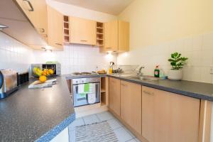 a kitchen with wooden cabinets and a counter top at The Point Apartment, Leeds City Center in Leeds