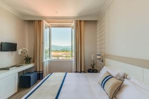 a bedroom with a large bed with a large window at Grand Hotel & Riviera in Lido di Camaiore +37 photos