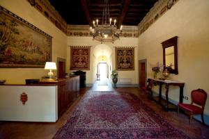 un couloir avec un lustre et un grand tapis dans l'établissement Villa Il Fedino, à San Casciano in Val di Pesa