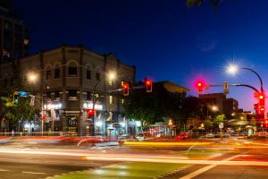a busy city street at night with red traffic lights at Ocean Island Inn | Backpackers | Suites in Victoria