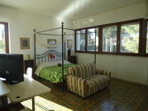 a bedroom with a bed and a chair and a desk at Villa Dafne in Bari