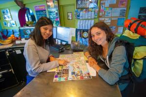 two women sitting at a table looking at a map at Ocean Island Inn | Backpackers | Suites in Victoria