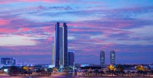 a city skyline with tall buildings and a cloudy sky at Dusit Thani Abu Dhabi in Abu Dhabi