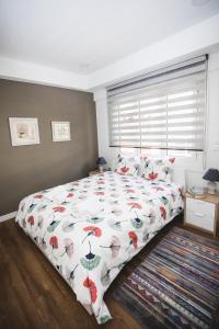 a bedroom with a bed with a comforter with umbrellas at Ziva Apartment - 4th floor - Renovated 2019 in Athens