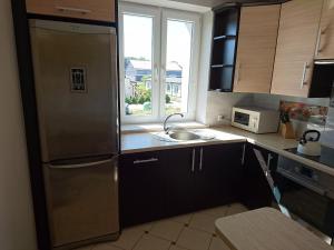 a kitchen with a stainless steel refrigerator and a sink at Apartament BRYZA in Darłowo