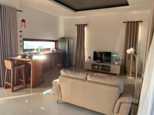 ein Wohnzimmer mit einem Sofa und einer Küche in der Unterkunft Villa Tiller 2 in Lembuak