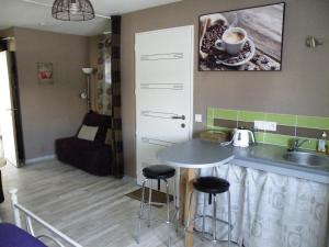 a kitchen with a sink and a table with stools at Les mouettes in Les Herbiers