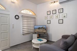 ein Wohnzimmer mit einem Sofa und einem TV in der Unterkunft the four seasons in Korfu-Stadt