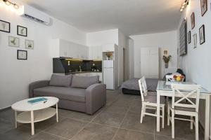 ein Wohnzimmer mit einem Sofa und einem Tisch in der Unterkunft the four seasons in Korfu-Stadt