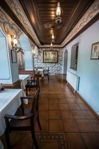 a room with tables and chairs and a stone wall at The House of the Miyaks in Rostuša