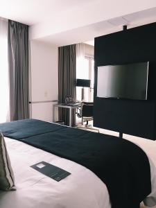 a hotel room with a television and a bed at 474 Buenos Aires Hotel in Buenos Aires