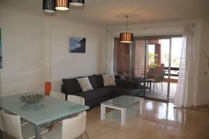 een woonkamer met een bank en een tafel bij Bel appartement avec vue sur mer in Arona