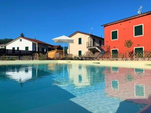 una piscina de agua frente a algunos edificios en Liguria Village en Brugnato