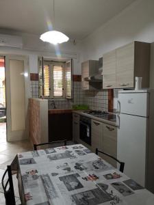 トッレ・ラピッロにあるCasa Vacanza Villa Teresaのキッチン(写真付きテーブル付)