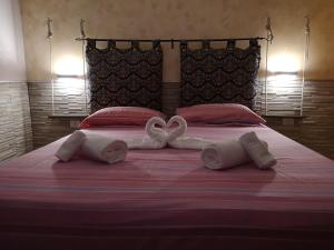 two towels in the shape of hearts on a bed at Casa Solemare in Torre Lapillo