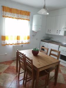 una cocina con una mesa de madera con un tazón. en EL MIRADOR DEL CORNEJA, en Mesegar de Corneja