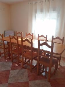 a wooden dining room table and chairs with a window at EL MIRADOR DEL CORNEJA in Mesegar de Corneja +10 photos