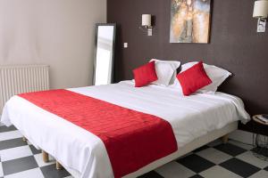 a bedroom with a large bed with red pillows at Cit'Hotel Europeen in Angoulême