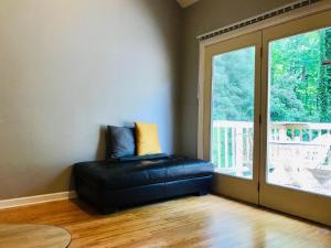 un sofá de cuero negro en una habitación con ventana en Zen House Of Downtown Decatur Emory Cdc en Decatur