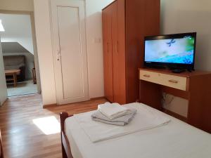 um quarto com uma cama e uma televisão num armário em Emi em Budva
