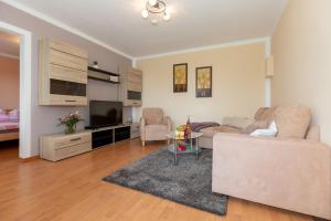 a living room with a couch and a tv at Bungalow Becker "Am Feldrand" in Jennewitz