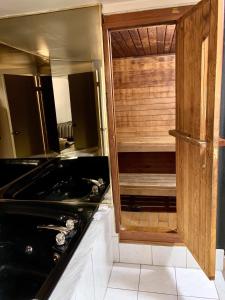 a bathroom with a black tub and a wooden cabinet at Deluxe Inn in Toronto