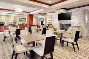 a restaurant with tables and chairs and a fireplace at Wingate by Wyndham Columbia/Lexington in Lexington