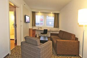 a living room filled with furniture and a tv at ibis Dresden Zentrum in Dresden