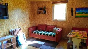 a living room with a red couch and a window at Domek Łukaszówka in Jonkowo