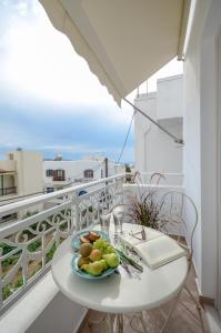 a table with a plate of fruit on a balcony at Smirida Suites in Naxos Chora