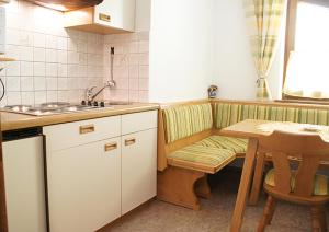 eine Küche mit einem Tisch, einem Stuhl und einem Waschbecken in der Unterkunft Haus Anton Schranz in Sankt Anton am Arlberg