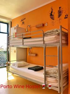 2 letti a castello in una camera con parete arancione di Porto Wine Hostel a Porto