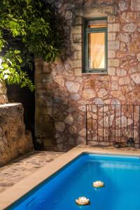 a swimming pool with two rocks in front of a building at Stone Built Villa Galatia, Poolside & Perfect View in Karés