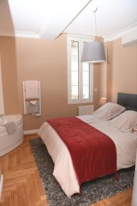 een slaapkamer met een groot bed en een rode deken bij Libourne Hyper Centre à deux pas de Saint Emilion in Libourne