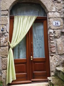 uma porta de madeira com uma janela num edifício de pedra em LA BICO' em Pitigliano