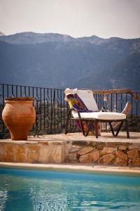 a chair and a vase next to a swimming pool at Stone Built Villa Galatia, Poolside & Perfect View in Karés