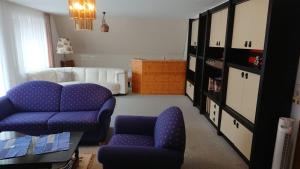 ein Wohnzimmer mit lila Stühlen und einem Sofa in der Unterkunft Kaufhaus Feldberg in Rinken