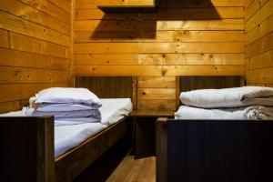 two beds in a room with wooden walls at Arest Vama Veche in Vama Veche