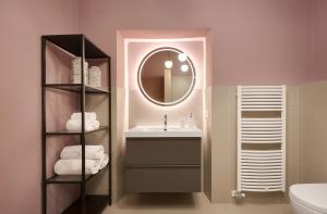 een badkamer met een wastafel en een spiegel bij Arte Apartments in Bolzano