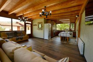 sala de estar con sofá y cocina en Piscina en Casa Rural con Encanto El Puentuco una de las casas mas valoradas de Cantabria, en Villacarriedo