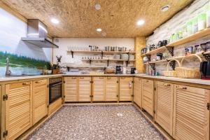 a large kitchen with wooden cabinets and shelves at City Center Garden Camping in Tallinn