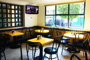 a room with tables and chairs in a restaurant at Hotel New York Ciudad de Mexico in Mexico City