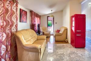 uma sala de estar com um sofá e um frigorífico vermelho em Villa Valentina em Premantura