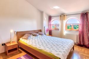um quarto com uma cama e duas janelas em Villa Valentina em Premantura