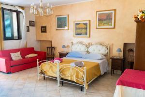 a bedroom with a bed and a red couch at Agriturismo Biologico Sant'Andrea in Castellaneta Marina