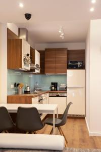 a kitchen with a white table and chairs at Center Rev Apartment in Győr